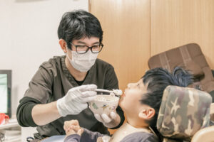 男性スタッフが男の子に食事介助をしている