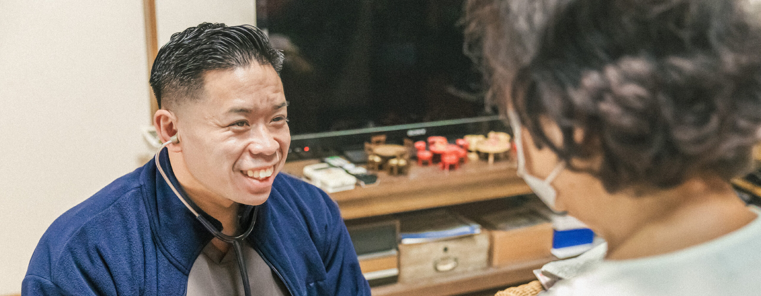 高齢女性に聴診器を当てる男性スタッフ