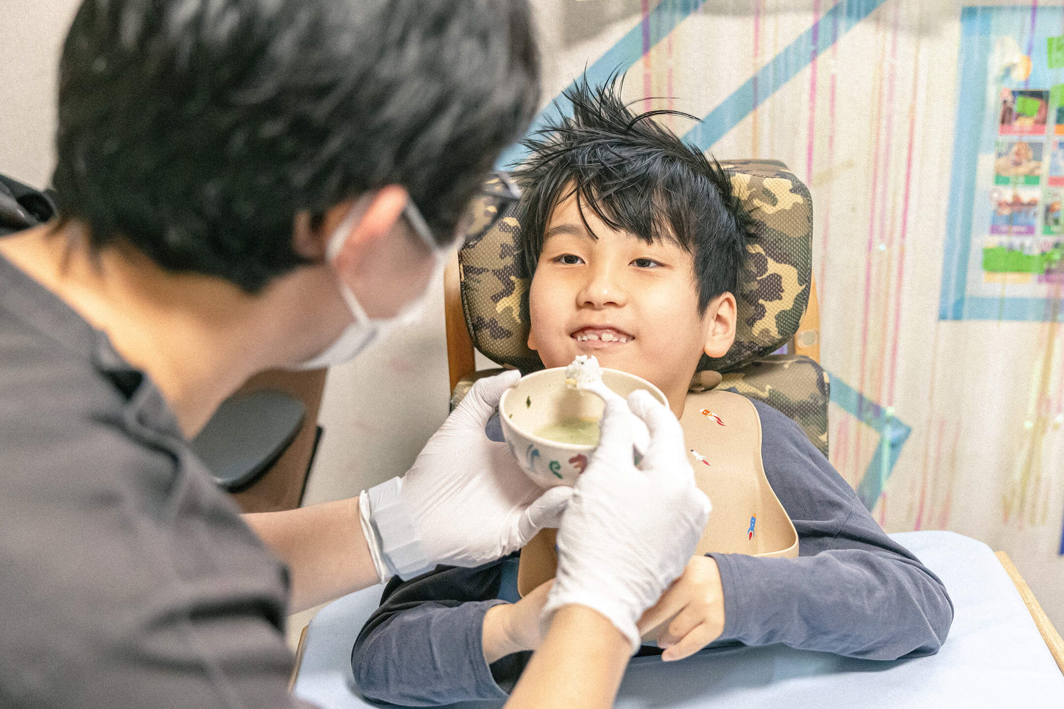 男の子が食事介助を受けている様子