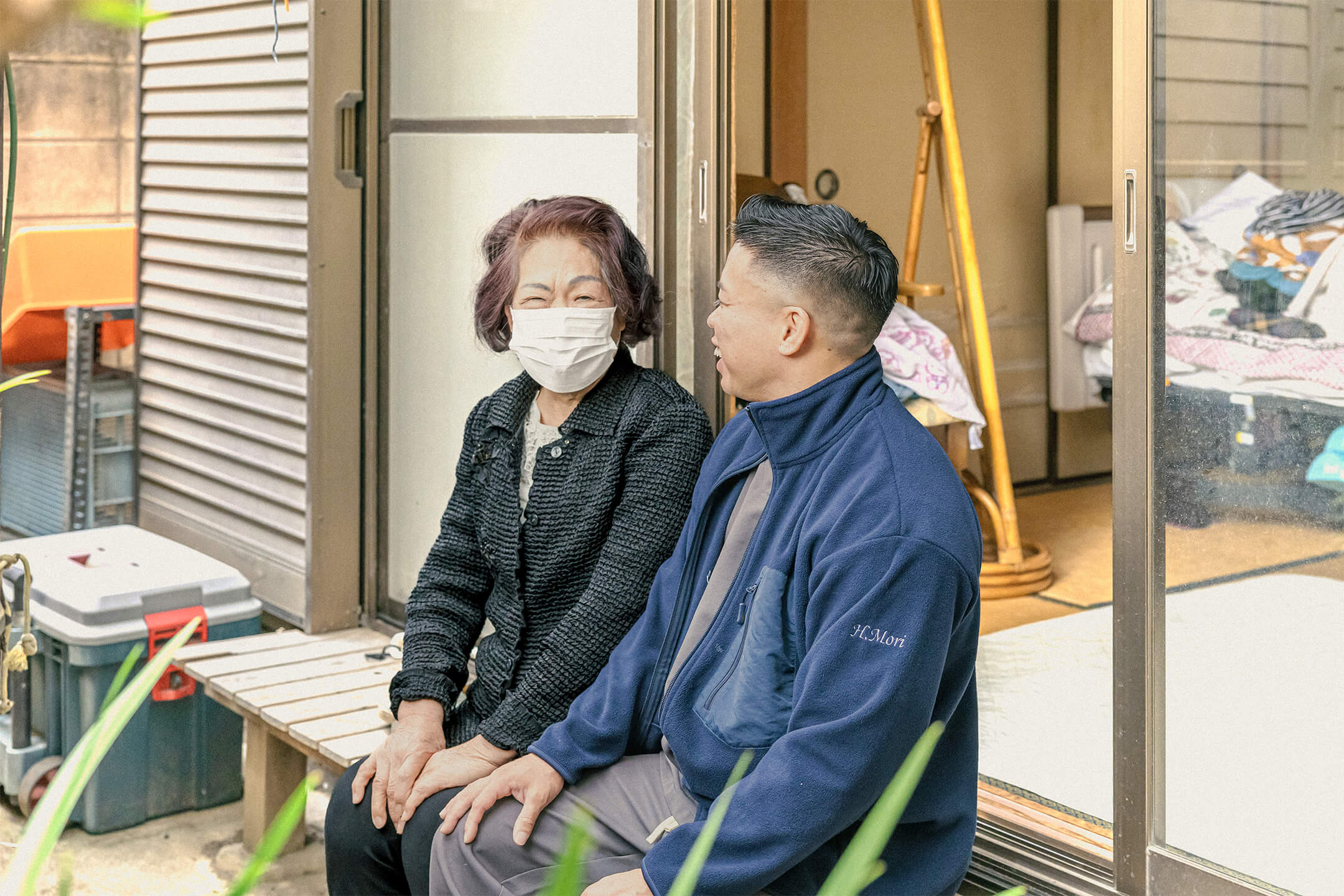 高齢女性と男性スタッフが縁側で談笑している