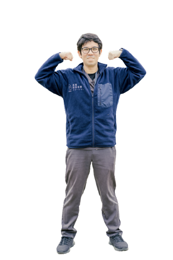 両手でムキムキポーズをしている男性スタッフ